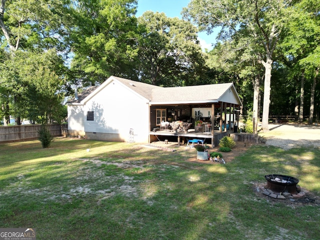 back of property featuring a lawn, fence, an outdoor fire pit, and crawl space