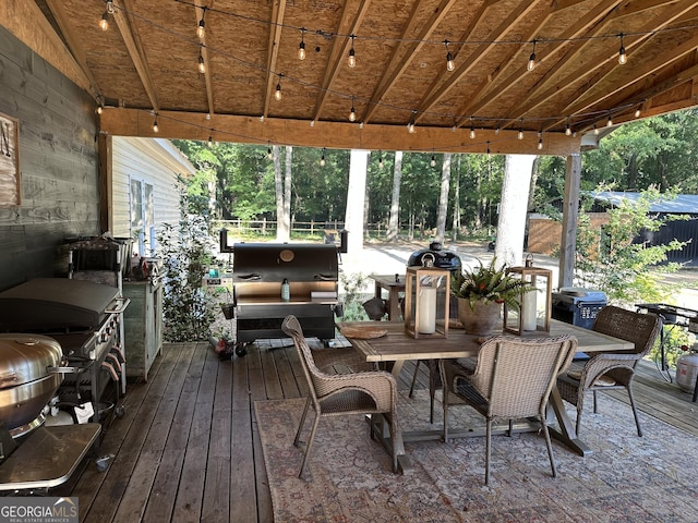 deck with fence, outdoor dining space, and grilling area