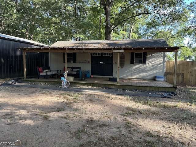 rear view of property with fence and covered porch