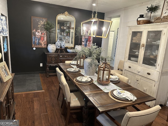 dining area with dark wood-style flooring and a textured ceiling