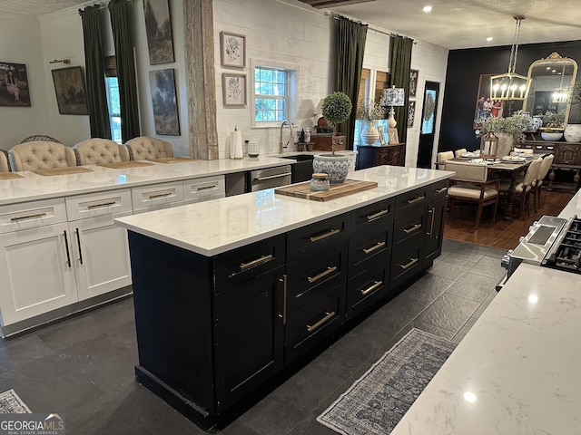 kitchen with dark cabinets, a textured ceiling, white cabinetry, and a notable chandelier