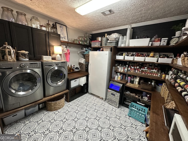 clothes washing area with crown molding, visible vents, washer and clothes dryer, a textured ceiling, and cabinet space