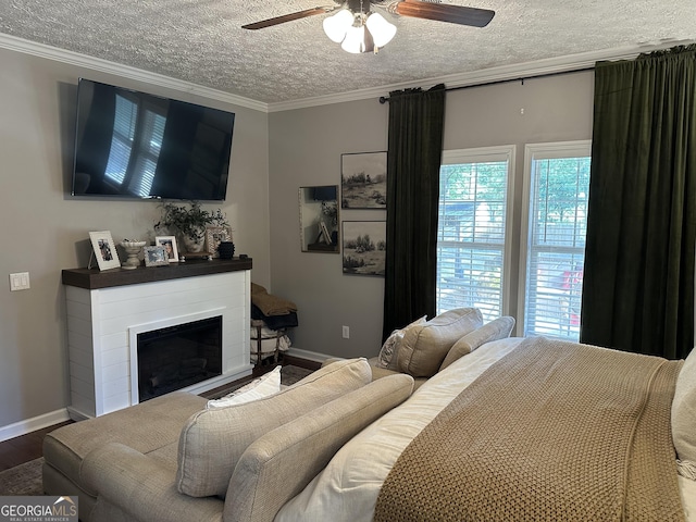 bedroom featuring baseboards, ornamental molding, a textured ceiling, and wood finished floors