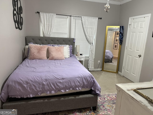 bedroom with carpet floors, crown molding, and baseboards
