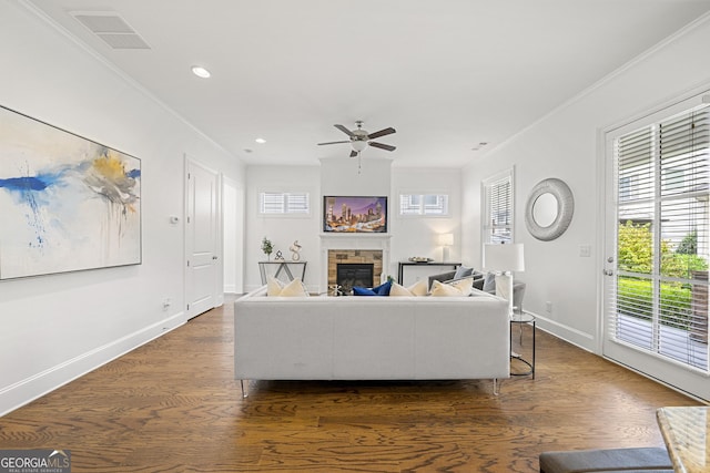 living area with a ceiling fan, baseboards, plenty of natural light, and a fireplace