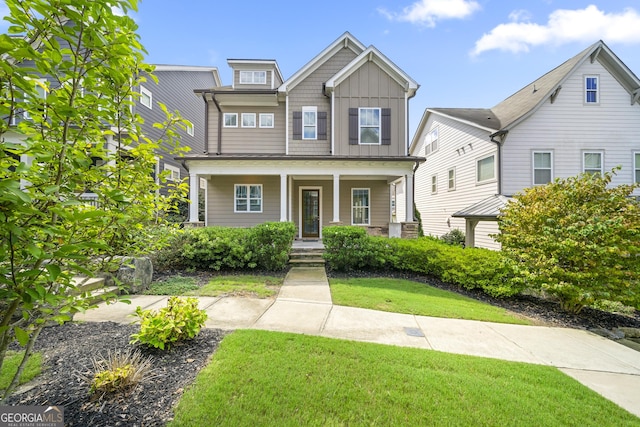 craftsman-style home with board and batten siding, a porch, and a front yard