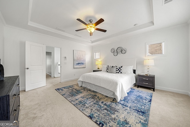 bedroom featuring a tray ceiling, visible vents, light carpet, and ornamental molding
