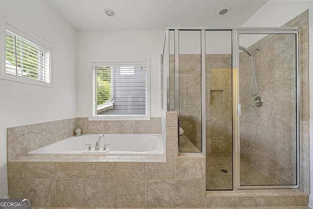 bathroom featuring a stall shower and a bath