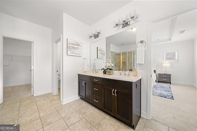 full bath with a sink, a shower stall, double vanity, and visible vents