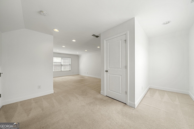 unfurnished room featuring visible vents, baseboards, and light colored carpet