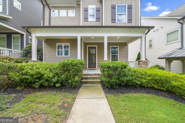 property entrance with covered porch and board and batten siding