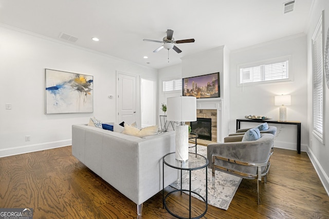 living room with visible vents, ornamental molding, a ceiling fan, and dark wood-style floors