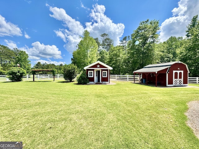 view of yard featuring fence, an outdoor structure, and a storage unit