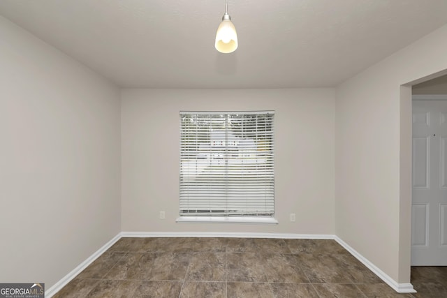 unfurnished room featuring baseboards