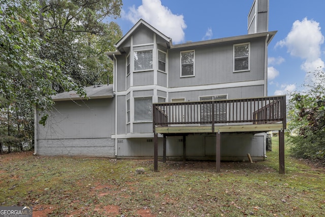 back of house featuring a chimney and a wooden deck