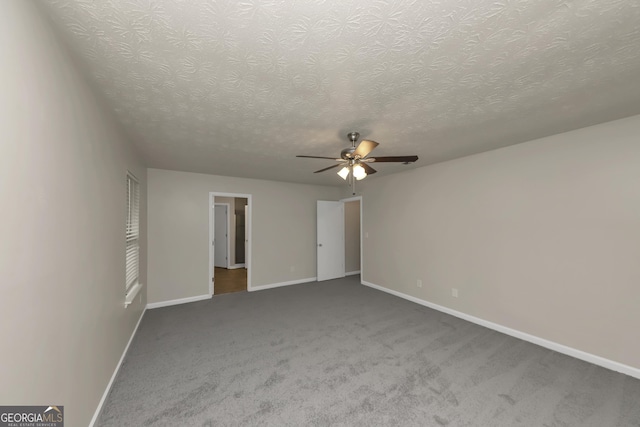 unfurnished bedroom featuring ceiling fan, a textured ceiling, carpet flooring, and baseboards
