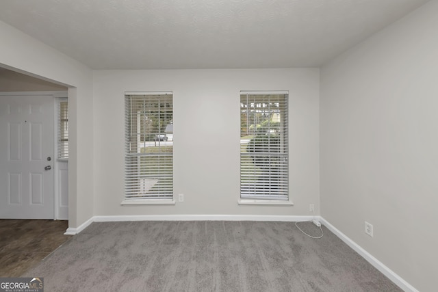empty room with baseboards and carpet floors