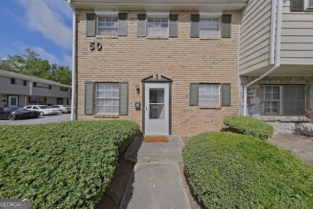 view of exterior entry with brick siding