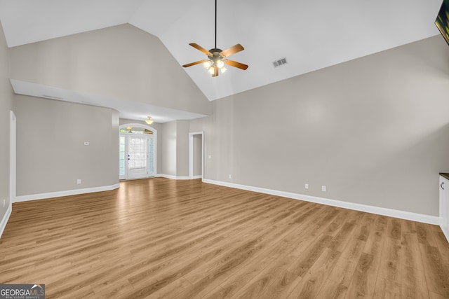 unfurnished living room with a ceiling fan, high vaulted ceiling, visible vents, and light wood-type flooring