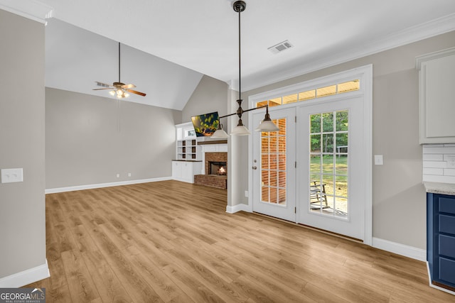doorway to outside with a ceiling fan, visible vents, a fireplace, baseboards, and light wood-style flooring