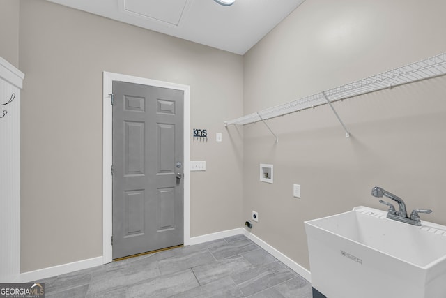 washroom with baseboards, laundry area, a sink, and hookup for a washing machine