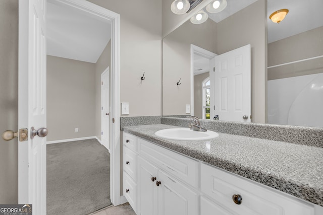 bathroom with vanity, baseboards, and tile patterned floors