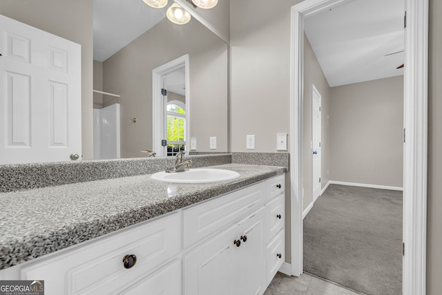 full bath featuring vanity, baseboards, and tile patterned flooring