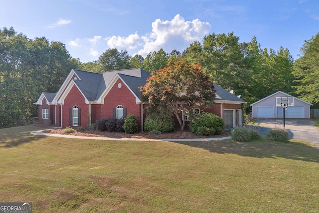 view of front of home with brick siding, a front lawn, an outbuilding, and a detached garage