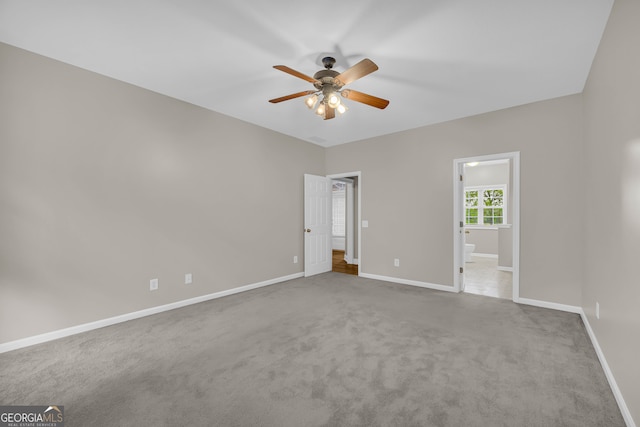 unfurnished bedroom featuring carpet flooring, baseboards, ceiling fan, and ensuite bathroom