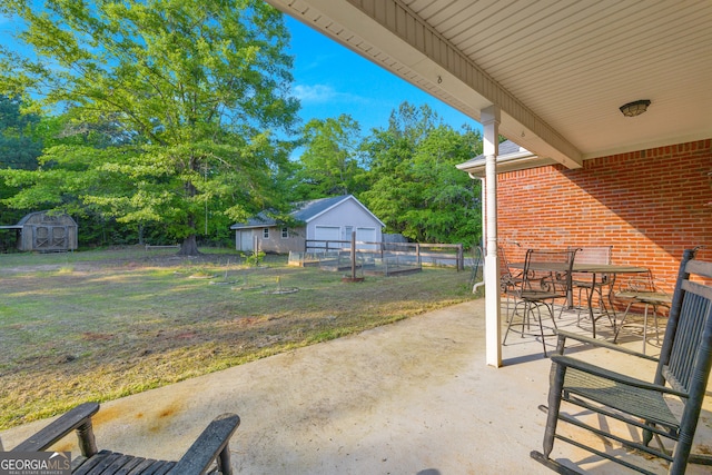 view of patio featuring an outdoor structure, fence, a storage unit, and outdoor dining space