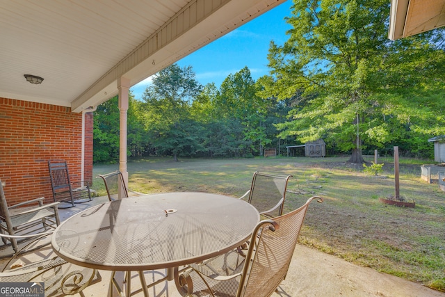 view of patio with outdoor dining area, an outbuilding, and a storage shed