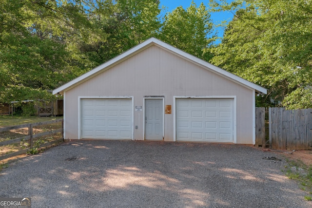 detached garage featuring fence