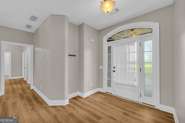 foyer entrance with baseboards, visible vents, and light wood-style floors
