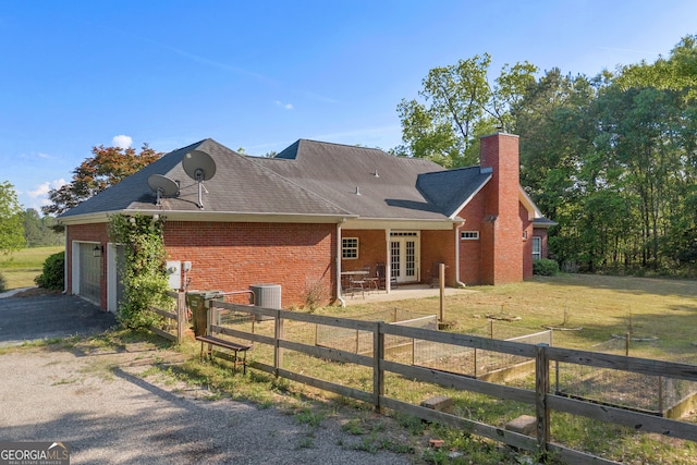 view of front of home with brick siding, fence, french doors, and central AC unit