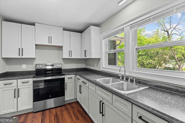 kitchen with a sink, a healthy amount of sunlight, white cabinets, and stainless steel range with electric cooktop