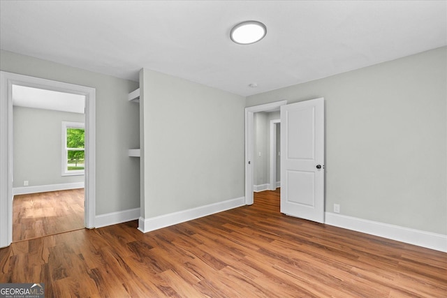 unfurnished bedroom with baseboards and wood finished floors