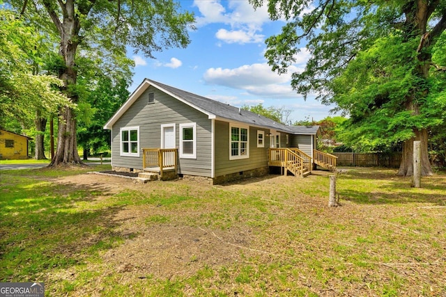 back of house with fence, a yard, and crawl space
