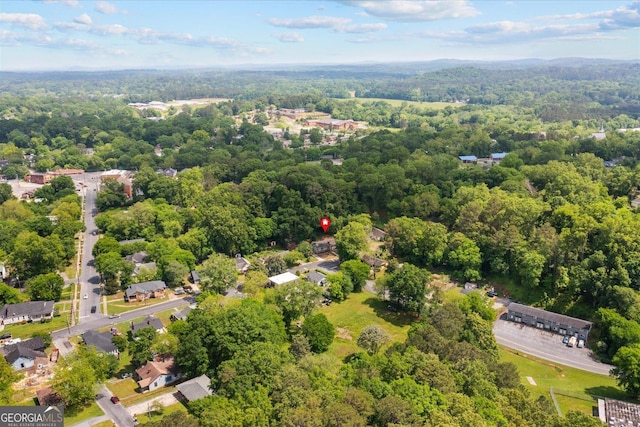 drone / aerial view featuring a wooded view