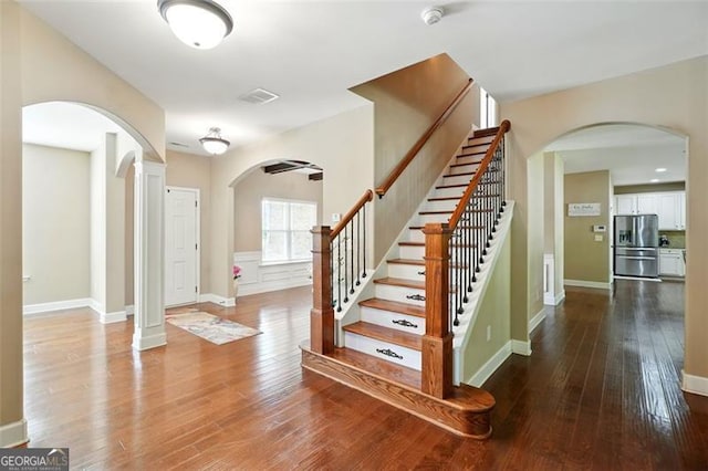 245 Tapestry Dr, Mcdonough, GA 30252 - staircase with arched walkways, baseboards, visible vents, and wood finished floors
