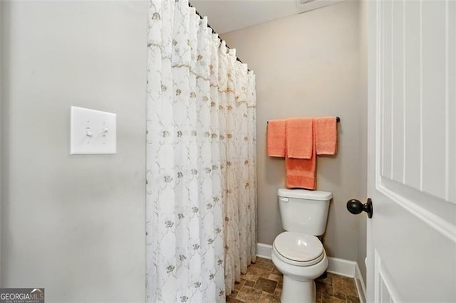 245 Tapestry Dr, Mcdonough, GA 30252 - full bath featuring baseboards, a shower with shower curtain, stone finish floor, and toilet