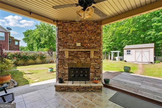 245 Tapestry Dr, Mcdonough, GA 30252 - view of patio / terrace with an outdoor structure, fence, an outdoor stone fireplace, a storage unit, and a ceiling fan