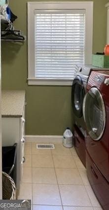 laundry room with a healthy amount of sunlight, separate washer and dryer, laundry area, and light tile patterned flooring