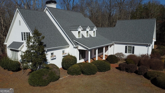 view of front of home featuring a shingled roof and a chimney
