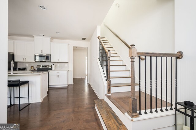 875 Venture Way SW, Atlanta, GA 30331 - kitchen with backsplash, visible vents, white cabinets, dark wood-style floors, and stainless steel appliances