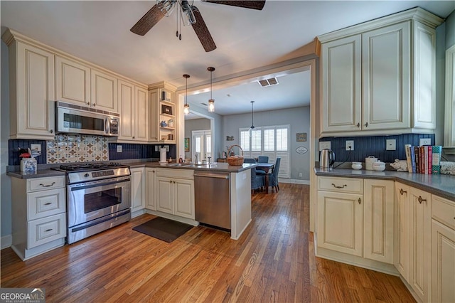 26 Kensington Rd, Avondale Estates, GA 30002 - kitchen with stainless steel appliances, cream cabinetry, dark countertops, and a peninsula