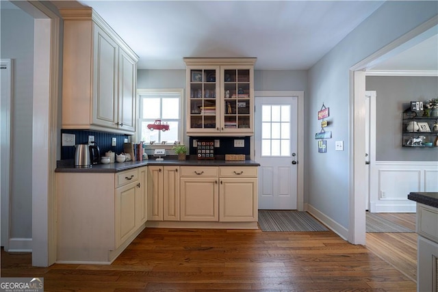 26 Kensington Rd, Avondale Estates, GA 30002 - kitchen featuring dark countertops, cream cabinets, wood finished floors, glass insert cabinets, and plenty of natural light