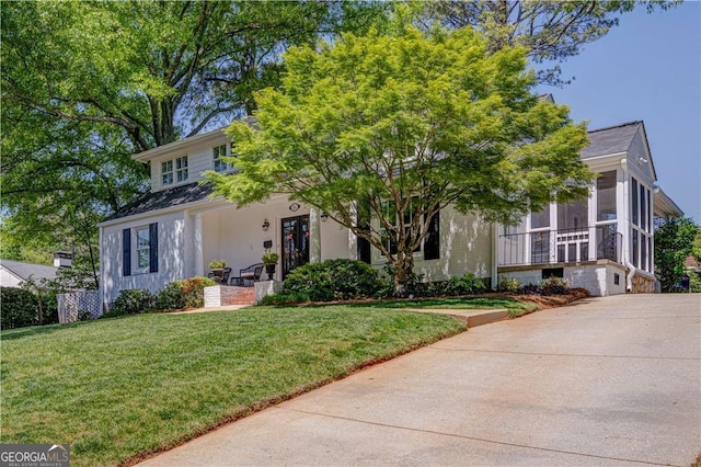 view of front facade featuring a sunroom and a front yard