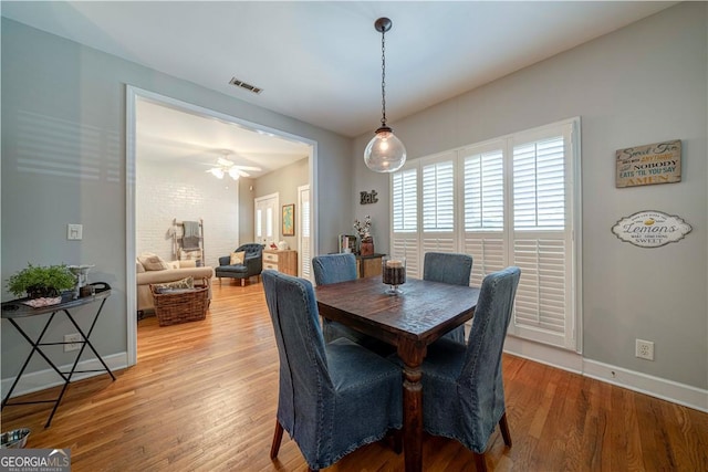 dining area featuring light wood-type flooring, baseboards, and ceiling fan