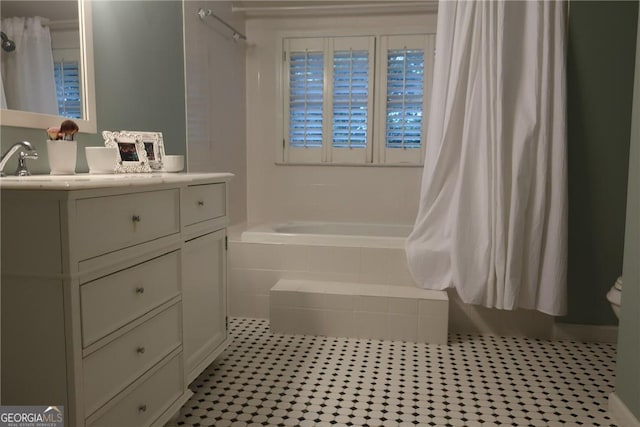bathroom featuring tile patterned floors, vanity, tiled shower / bath combo, and toilet