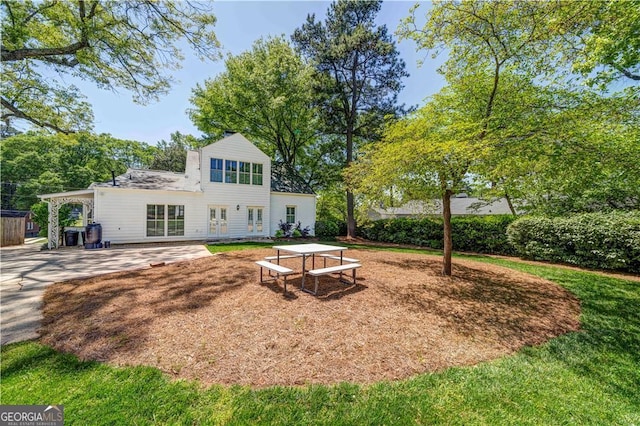 rear view of property featuring a patio and a yard